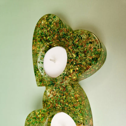Castiçal decorativo duplo em forma de coração, resina epóxi verde com acabamento translúcido e inclusões metálicas, vista em perspetiva