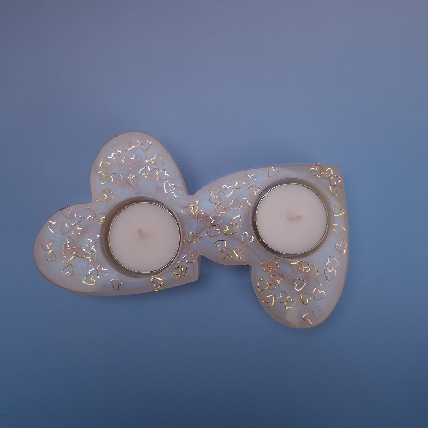 Porta-velas duplo em forma de dois corações interligados, feito em resina epóxi pérola translúcida com corações dourados e duas velas tealight