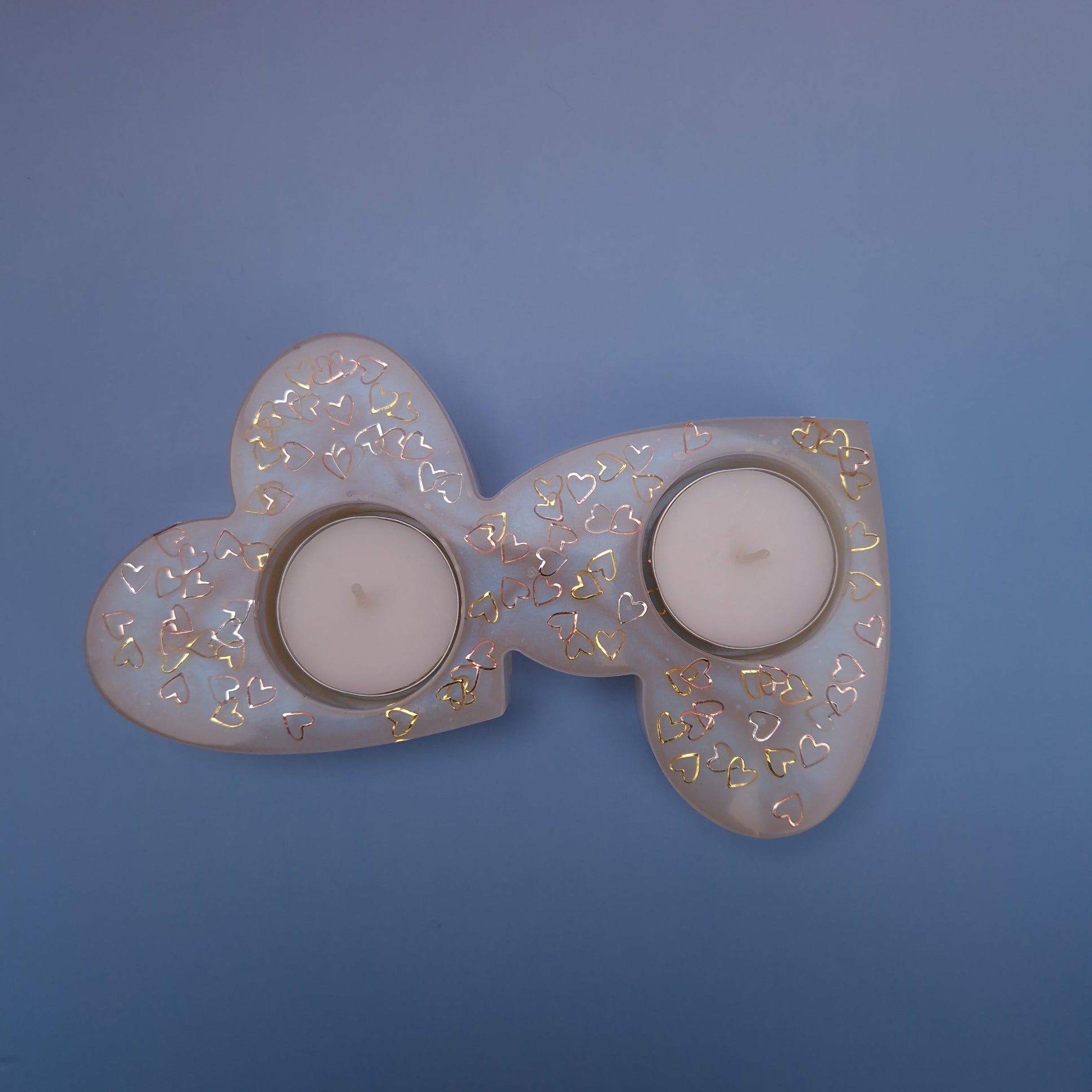 Porta-velas duplo em forma de dois corações interligados, feito em resina epóxi pérola translúcida com corações dourados e duas velas tealight