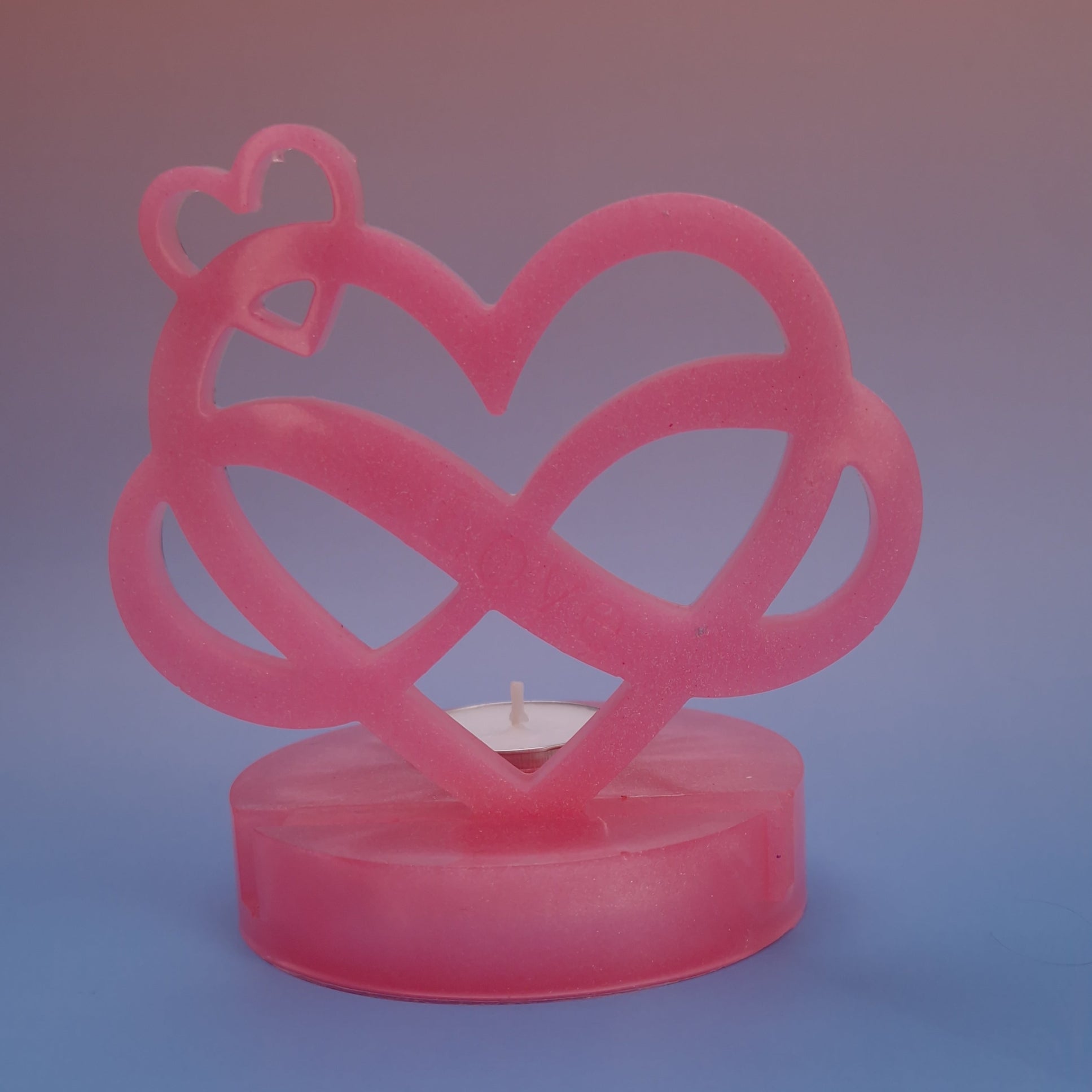 Castiçal decorativo em resina epóxi rosa perolado com design de coração infinito e vela tealight ao centro