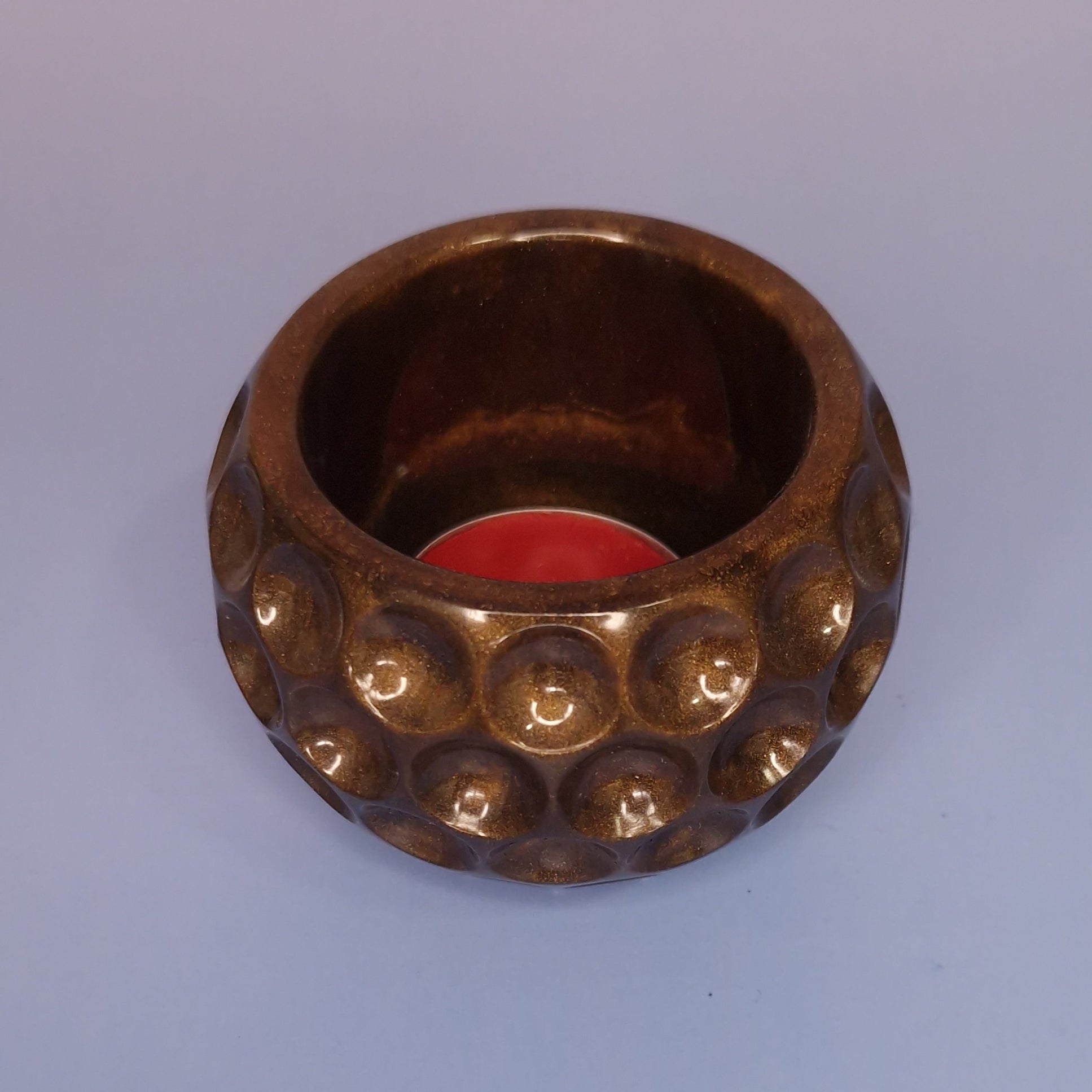 Porta-vela tealight dourado em resina artesanal com acabamento metálico, vista superior