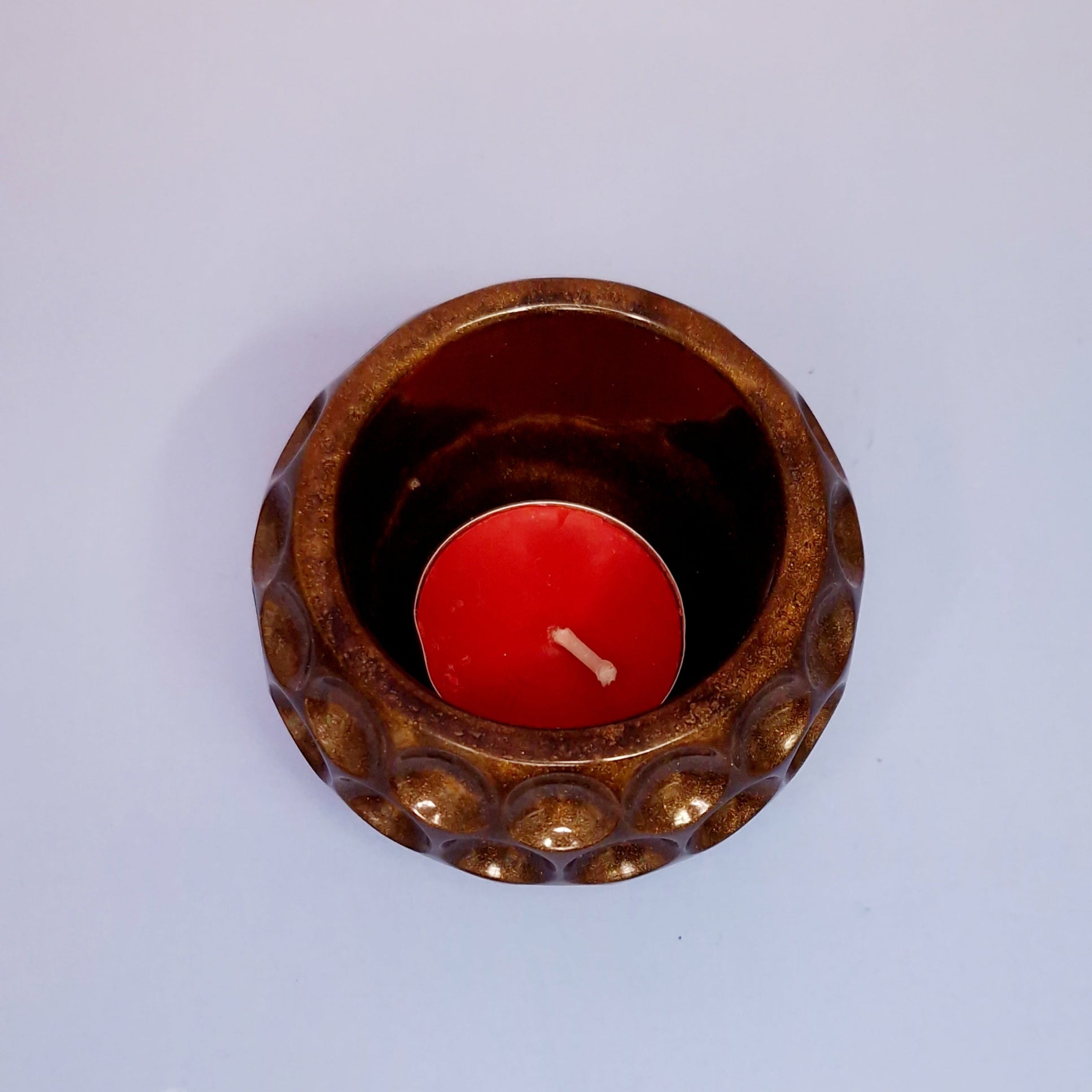 Castiçal em resina dourada com vela tealight vermelha, detalhe interior visto de cima