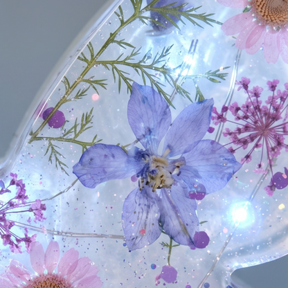 Pormenor das flores naturais preservadas na Borboleta Alice, destacando os tons rosa, lilás e os detalhes delicados da composição.