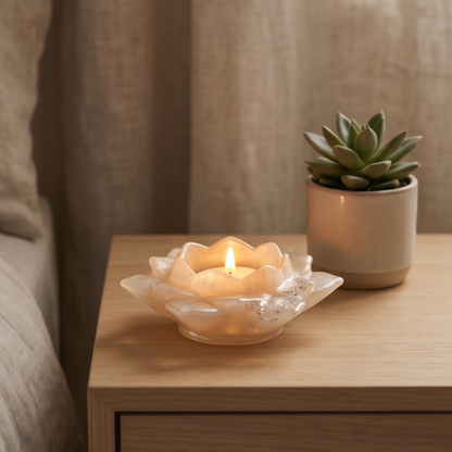Porta-velas decorativo flor de lótus em resina epóxi branco perlado com folha de prata numa mesa de cabeceira, peça artesanal para decoração de quarto.