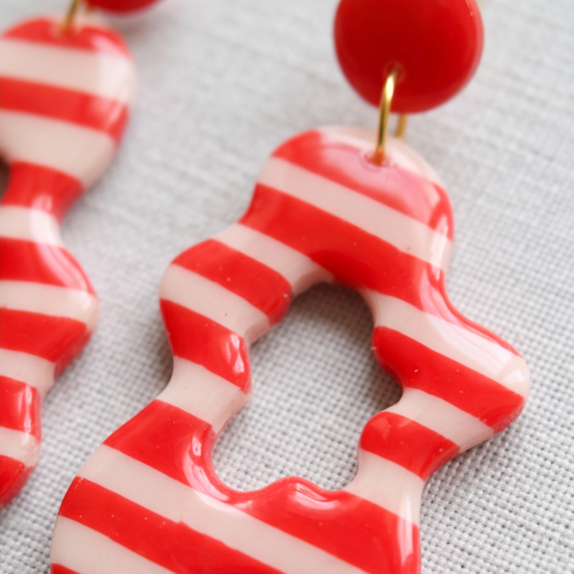Close-up de brincos artesanais em argila polimérica Brisa vermelho da Sweet Art