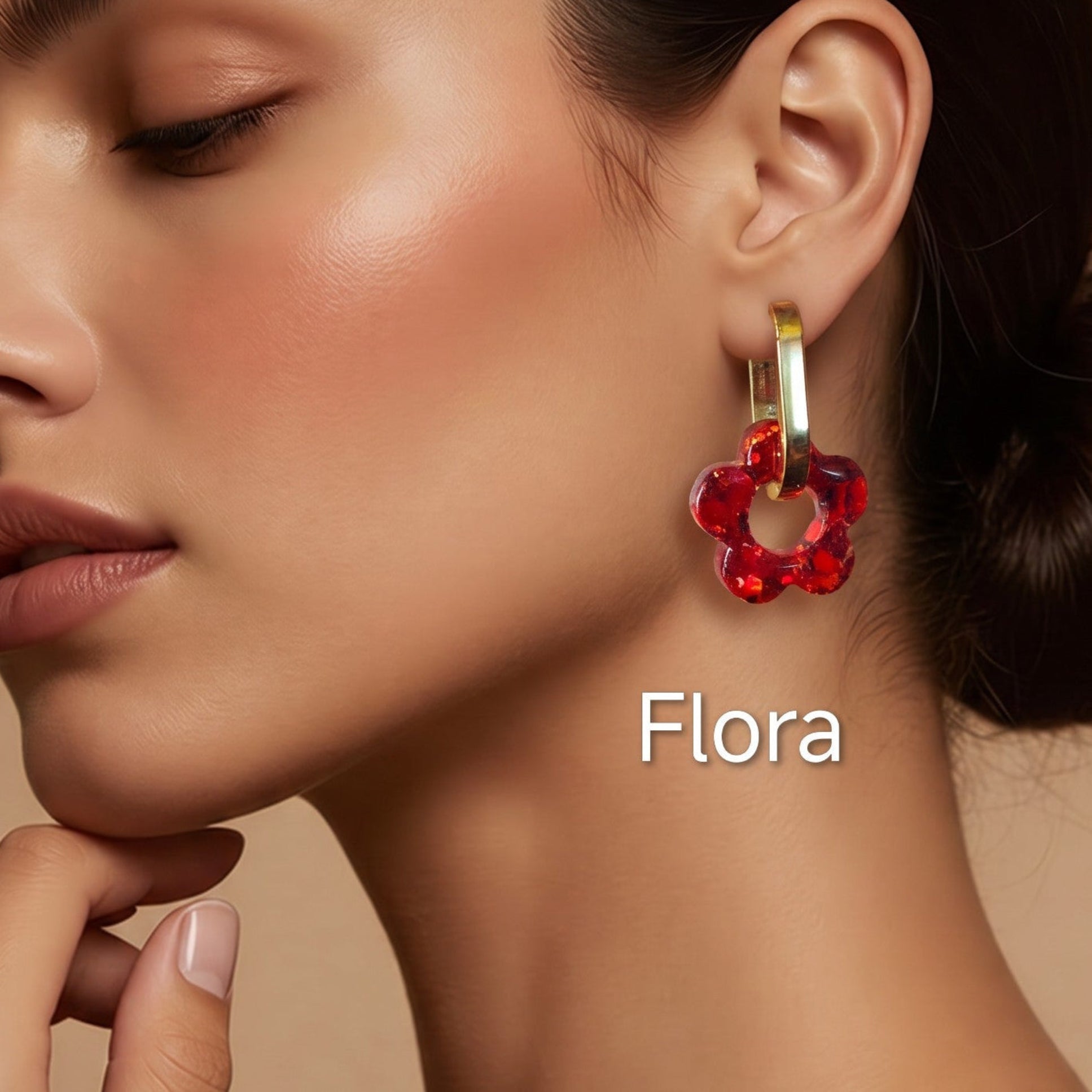 Modelo a usar brincos Flora em forma de flor vermelha, criados artesanalmente em resina epóxi pela Sweet Art.