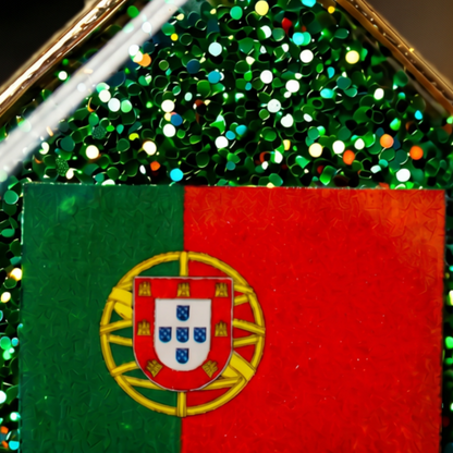 Close-up dos brincos artesanais com Bandeira de Portugal em resina epóxi verde, acabamento brilhante e detalhes dourados.